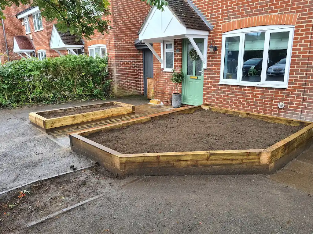 Garden landscaping with new lawn, paving and timber sleeper planters by Bracknell Fencing LTD in Berkshire