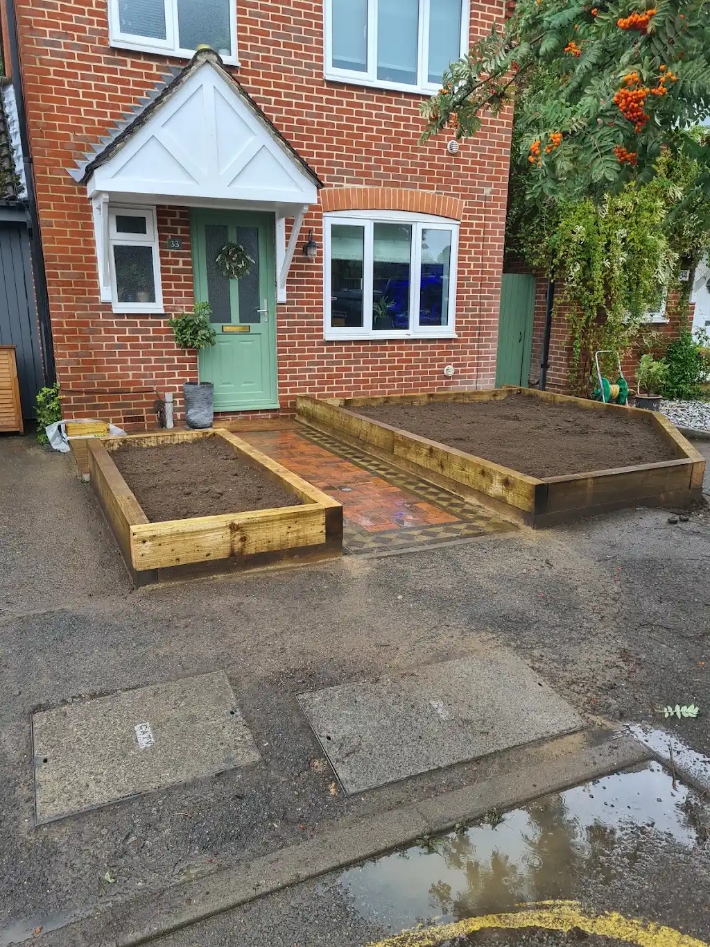 Garden landscaping with new lawn, paving and timber sleeper planters by Bracknell Fencing LTD in Berkshire