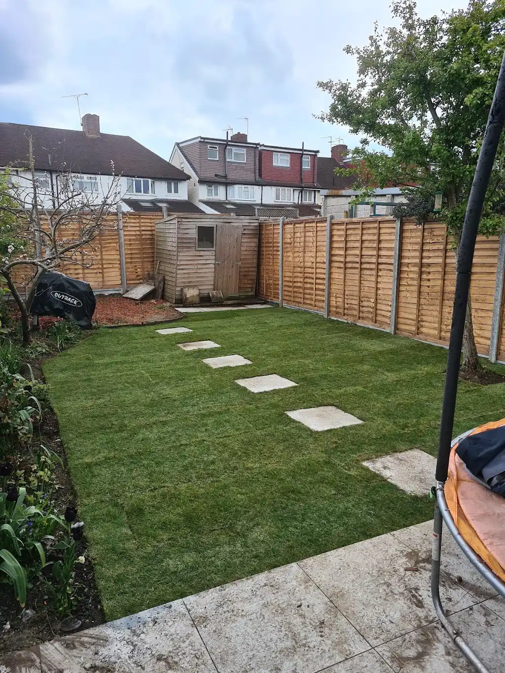Garden landscaping with new lawn, paving and timber sleeper planters by Bracknell Fencing LTD in Berkshire